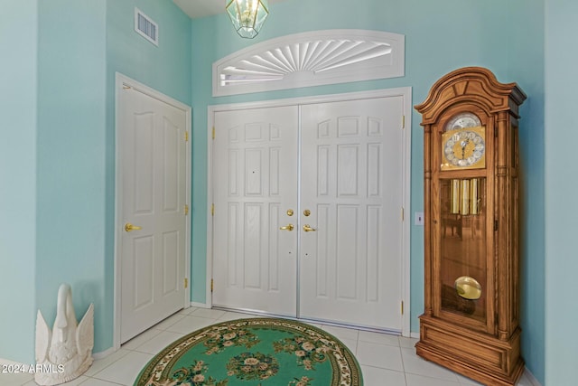 tiled foyer featuring a chandelier