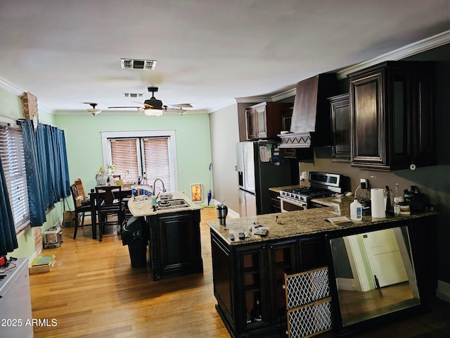 723 E Moreland St, Phoenix, AZ 85006 - kitchen with stainless steel gas range oven, a sink, ceiling fan, light wood-style flooring, and a center island