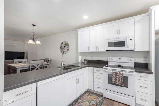 kitchen featuring pendant lighting, white appliances, sink, and white cabinets