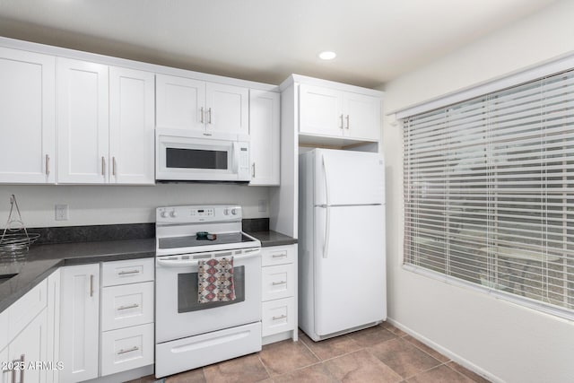 kitchen featuring white cabinetry, light tile patterned floors, and white appliances