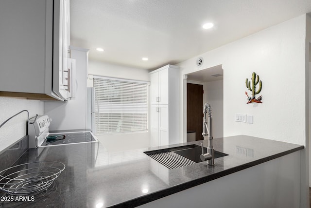 kitchen featuring sink, range with electric cooktop, and white cabinets