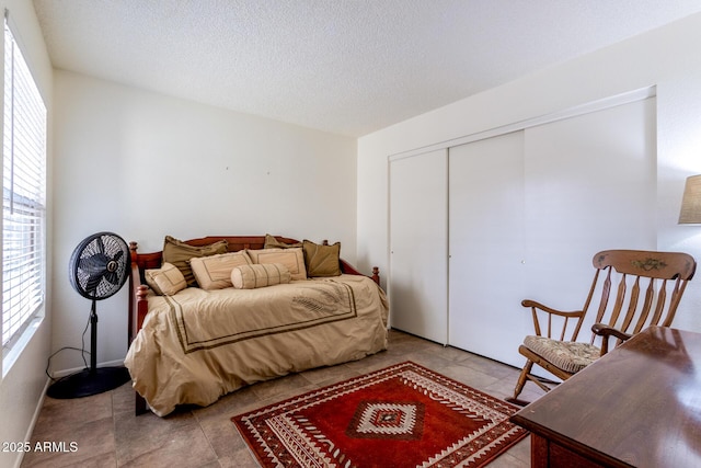 tiled bedroom featuring a closet and a textured ceiling