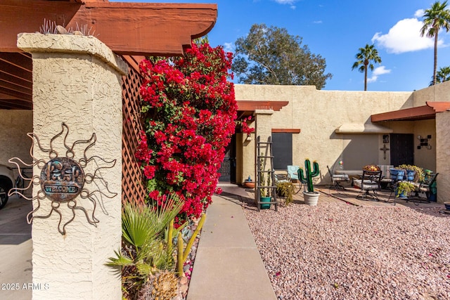 view of exterior entry with a patio