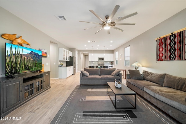 living room with ceiling fan and light wood-type flooring