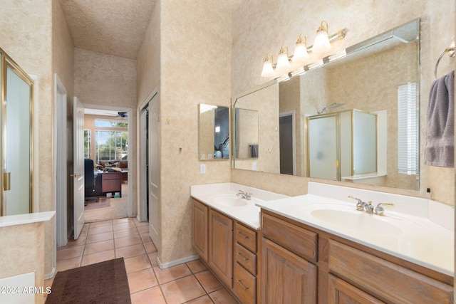 bathroom with vanity, a shower with shower door, and tile patterned flooring