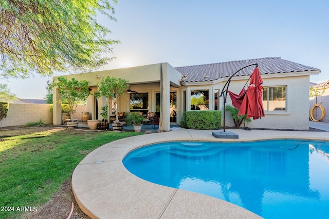 rear view of house featuring a patio, a fenced in pool, ceiling fan, and a yard