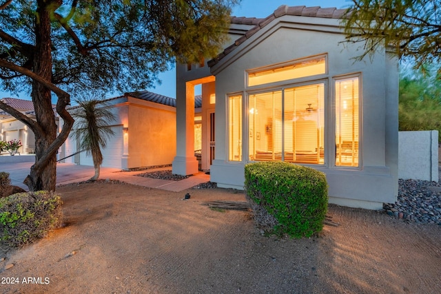 mediterranean / spanish-style house featuring a garage, a tiled roof, driveway, and stucco siding