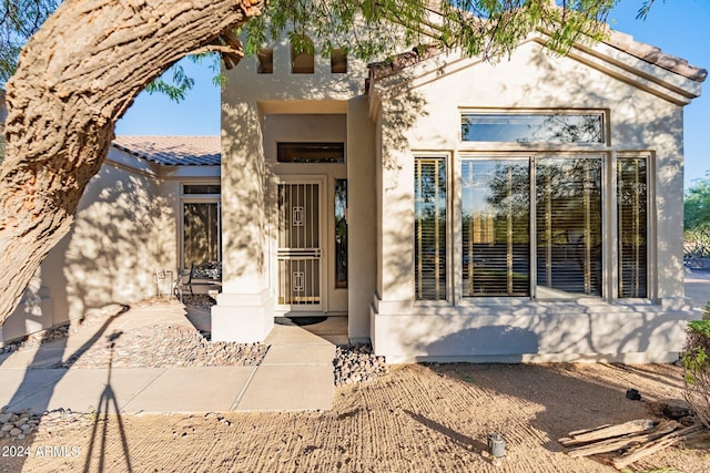 doorway to property with a tiled roof and stucco siding