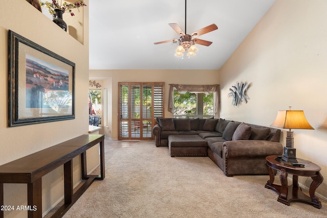 carpeted living room with ceiling fan and high vaulted ceiling