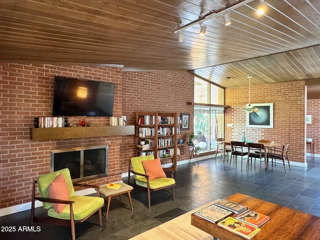 712 W Vernon Ave, Phoenix, AZ 85007 - living area with lofted ceiling, baseboards, brick wall, rail lighting, and a fireplace