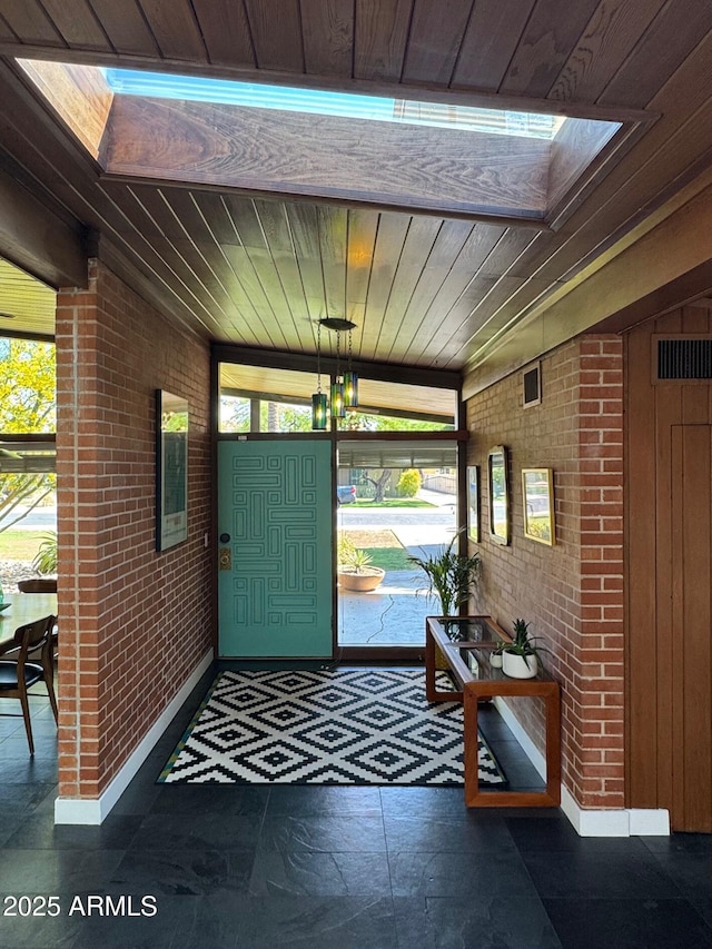 712 W Vernon Ave, Phoenix, AZ 85007 - foyer featuring baseboards, brick wall, and wooden ceiling