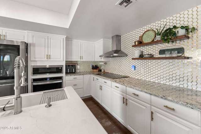 4392 W Charro Ln, Yuma, AZ 85365 - kitchen with wall chimney range hood, appliances with stainless steel finishes, white cabinets, backsplash, and a sink
