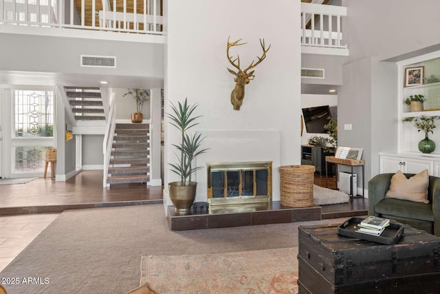 4392 W Charro Ln, Yuma, AZ 85365 - living area featuring stairs, a towering ceiling, and a tiled fireplace