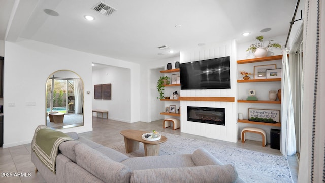 living room featuring light tile patterned flooring and built in features