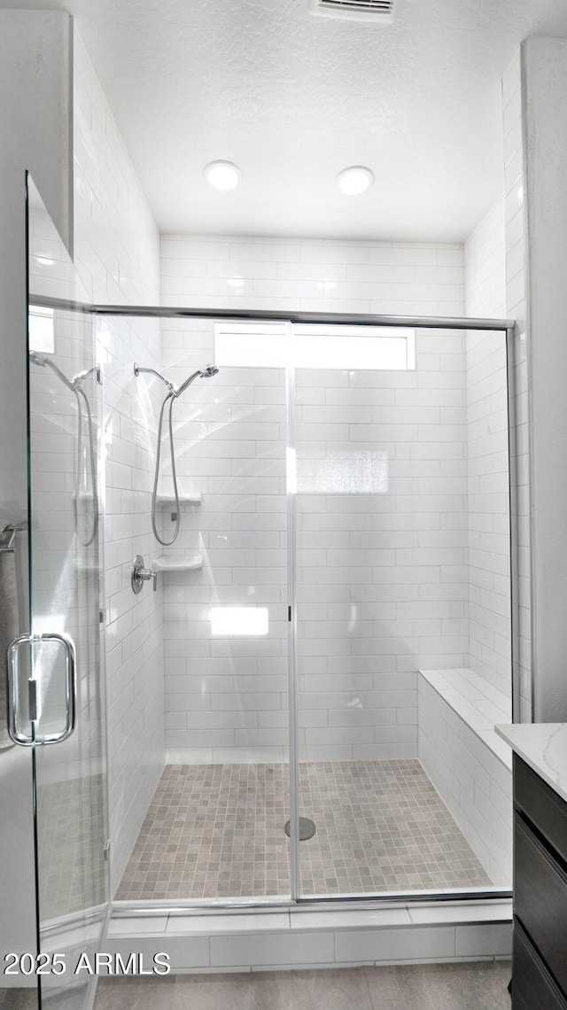 bathroom featuring walk in shower and vanity