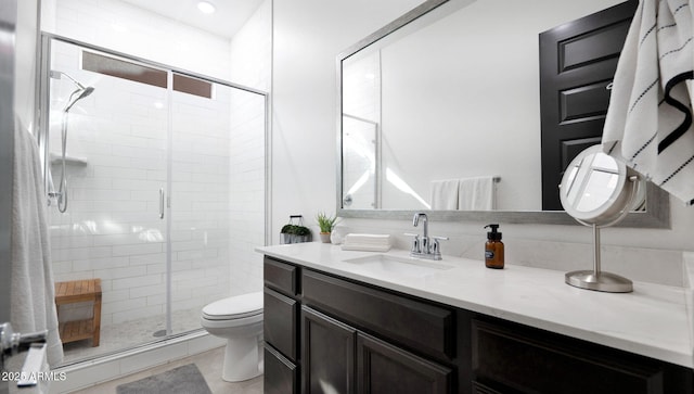 bathroom with vanity, toilet, and a shower with shower door