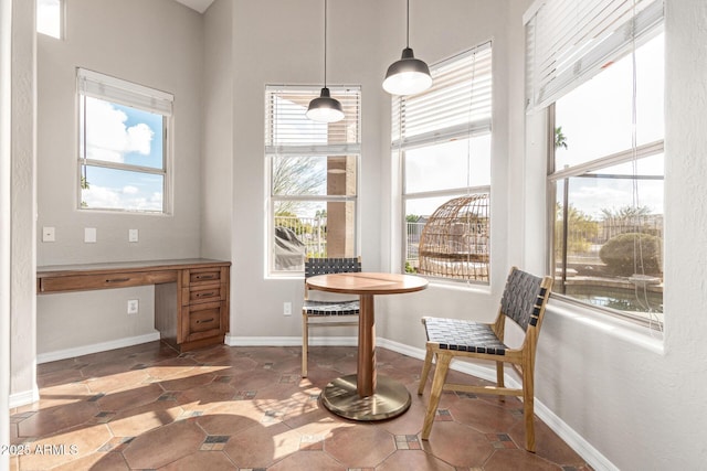 dining space with built in desk and plenty of natural light