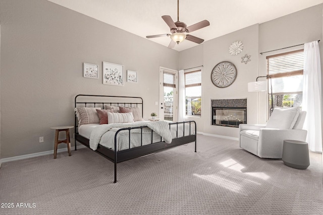 bedroom with multiple windows, carpet floors, ceiling fan, and a multi sided fireplace