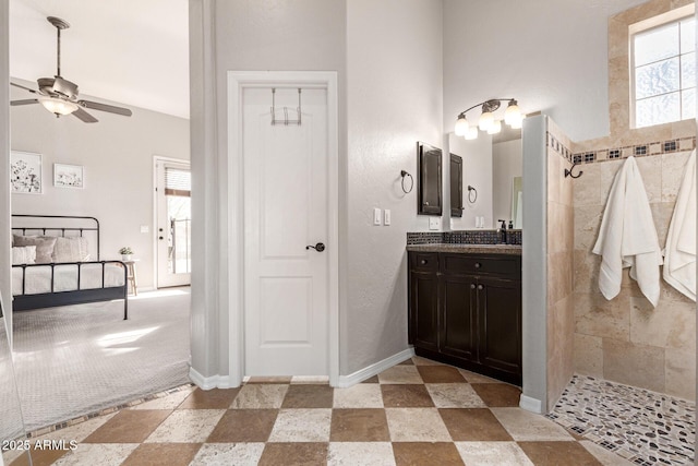 bathroom with vanity, a wealth of natural light, and tiled shower