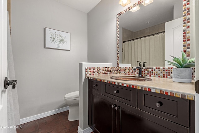 bathroom featuring tasteful backsplash, tile patterned floors, vanity, and toilet