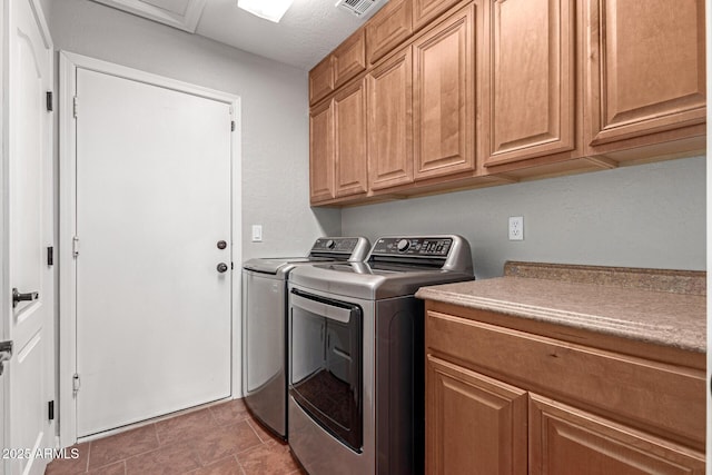 washroom with cabinets and washer and clothes dryer