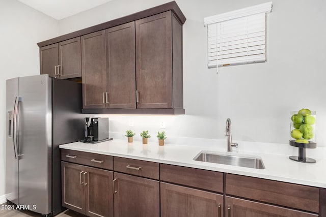 kitchen featuring stainless steel fridge with ice dispenser, sink, and dark brown cabinets