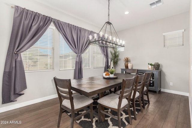 dining room with dark wood-type flooring and a chandelier