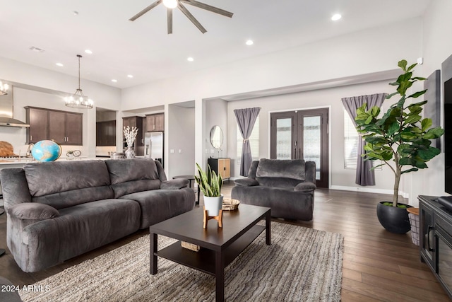 living room with dark hardwood / wood-style flooring and ceiling fan with notable chandelier