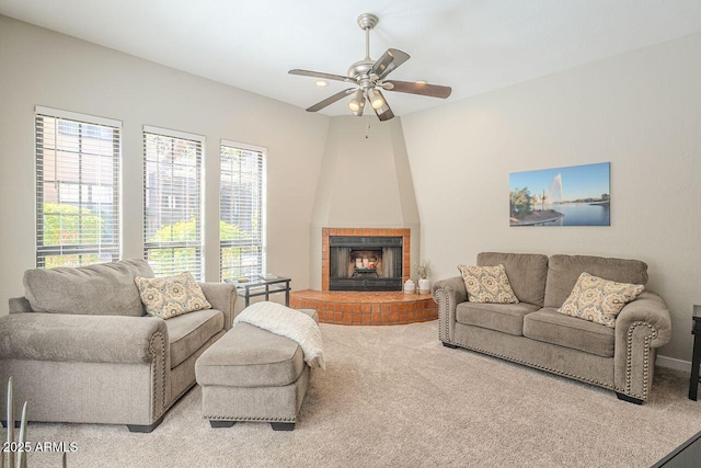 carpeted living room with a fireplace and ceiling fan