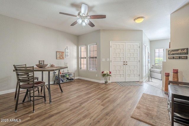 dining space featuring wood finished floors, baseboards, and ceiling fan