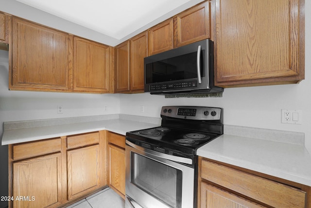 kitchen with light tile patterned floors and stainless steel appliances