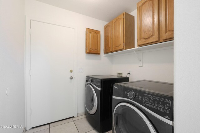 washroom with cabinets, independent washer and dryer, and light tile patterned floors