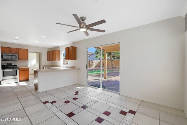 kitchen featuring kitchen peninsula, light tile patterned floors, stainless steel appliances, and ceiling fan