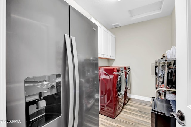 washroom with cabinets, separate washer and dryer, and light hardwood / wood-style floors