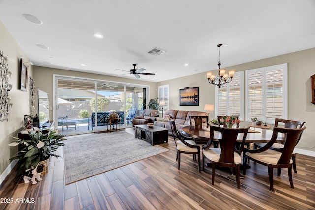 dining room with ceiling fan with notable chandelier and hardwood / wood-style floors