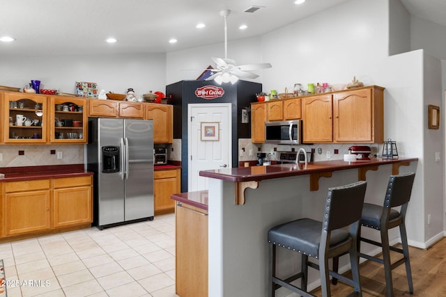 7300 Butte Vis, Prescott Valley, AZ 86315 - kitchen with a kitchen breakfast bar, stainless steel appliances, dark countertops, visible vents, and a peninsula