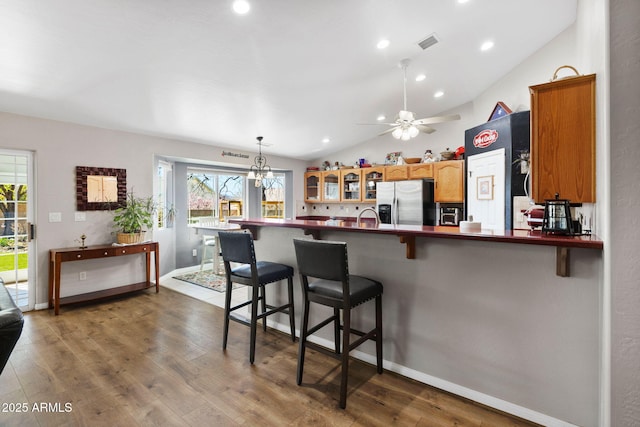 7300 Butte Vis, Prescott Valley, AZ 86315 - kitchen with visible vents, wood finished floors, lofted ceiling, stainless steel refrigerator with ice dispenser, and a kitchen breakfast bar