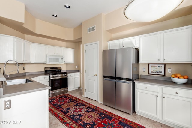 kitchen featuring stainless steel appliances, white cabinetry, sink, and light tile patterned floors