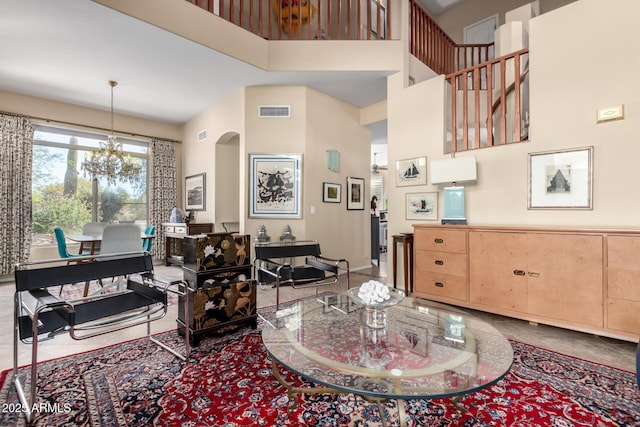 living room with an inviting chandelier and a towering ceiling