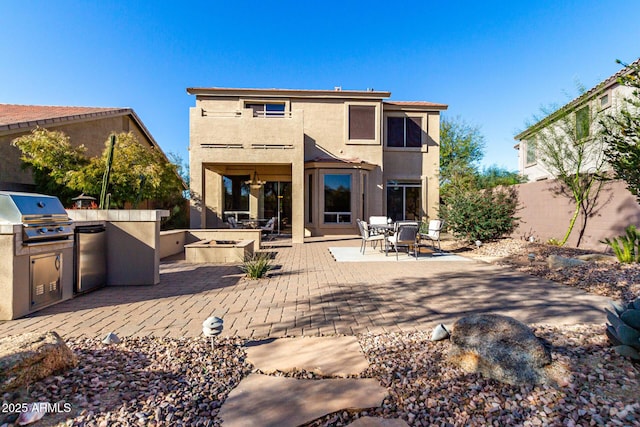 rear view of house featuring an outdoor kitchen and a patio