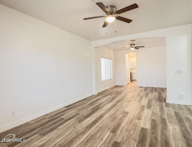 10722 W Quartz Dr, Casa Grande, AZ 85193 - unfurnished room featuring a ceiling fan, wood finished floors, and arched walkways