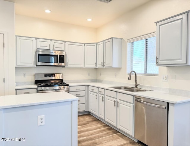 10722 W Quartz Dr, Casa Grande, AZ 85193 - kitchen featuring appliances with stainless steel finishes, light wood-type flooring, light countertops, recessed lighting, and white cabinetry