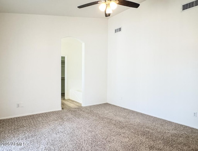 10722 W Quartz Dr, Casa Grande, AZ 85193 - empty room featuring carpet flooring, a ceiling fan, and arched walkways
