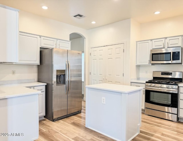 10722 W Quartz Dr, Casa Grande, AZ 85193 - kitchen with appliances with stainless steel finishes, arched walkways, light wood-style floors, light countertops, and recessed lighting