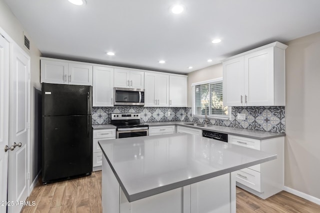 kitchen with a kitchen island, sink, white cabinetry, and black appliances