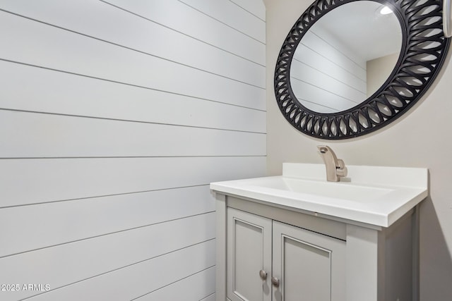 bathroom with vanity and wooden walls