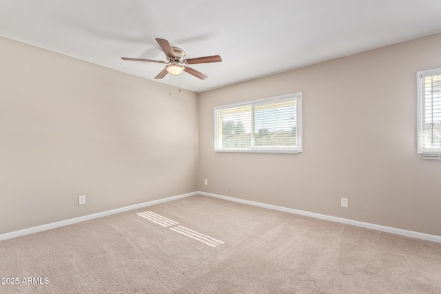 carpeted spare room with ceiling fan and plenty of natural light