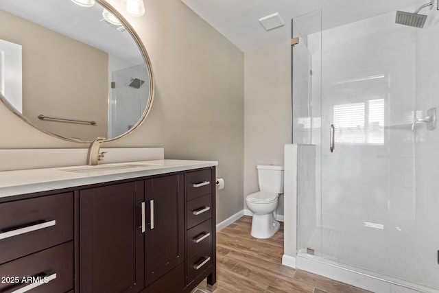 bathroom featuring a shower with door, wood-type flooring, toilet, and vanity