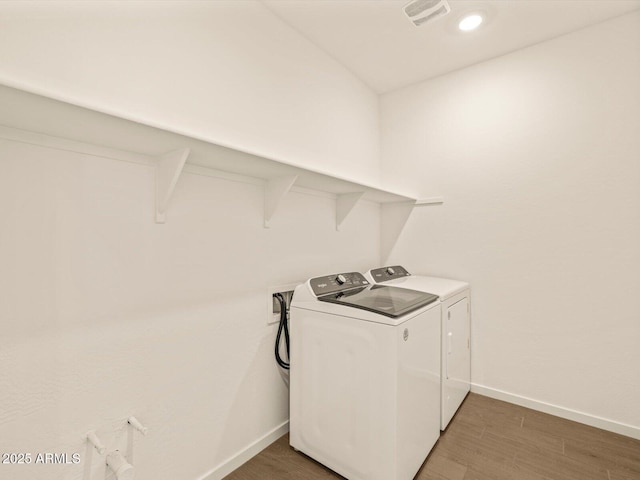 laundry room with dark hardwood / wood-style flooring and separate washer and dryer