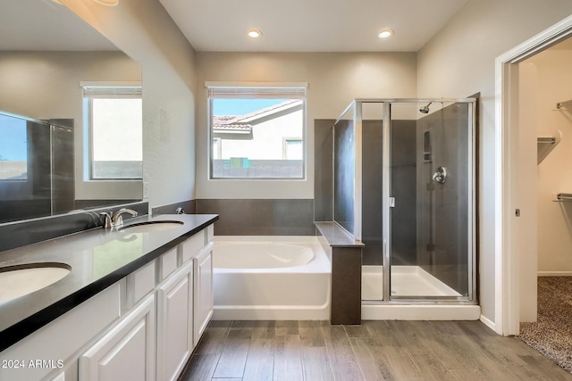 bathroom with hardwood / wood-style floors, vanity, and independent shower and bath